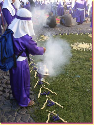 A liitle boy waves burning incense over a simple carpet, as the procession is coming ... click to see a large image