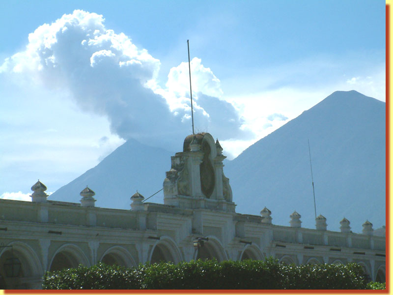 Volcanoes Fuego and Acotenango, from Antigua's main square, the Parque Central, with the Palacio de los Capitanes in the foreground